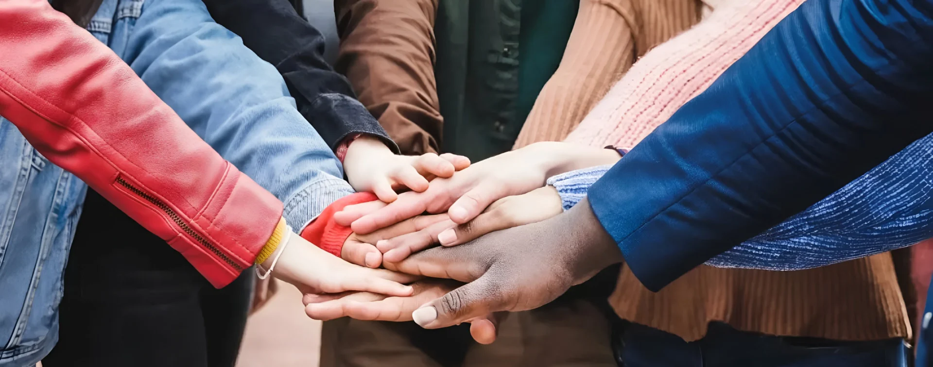 A group of people holding hands in the middle of each other.